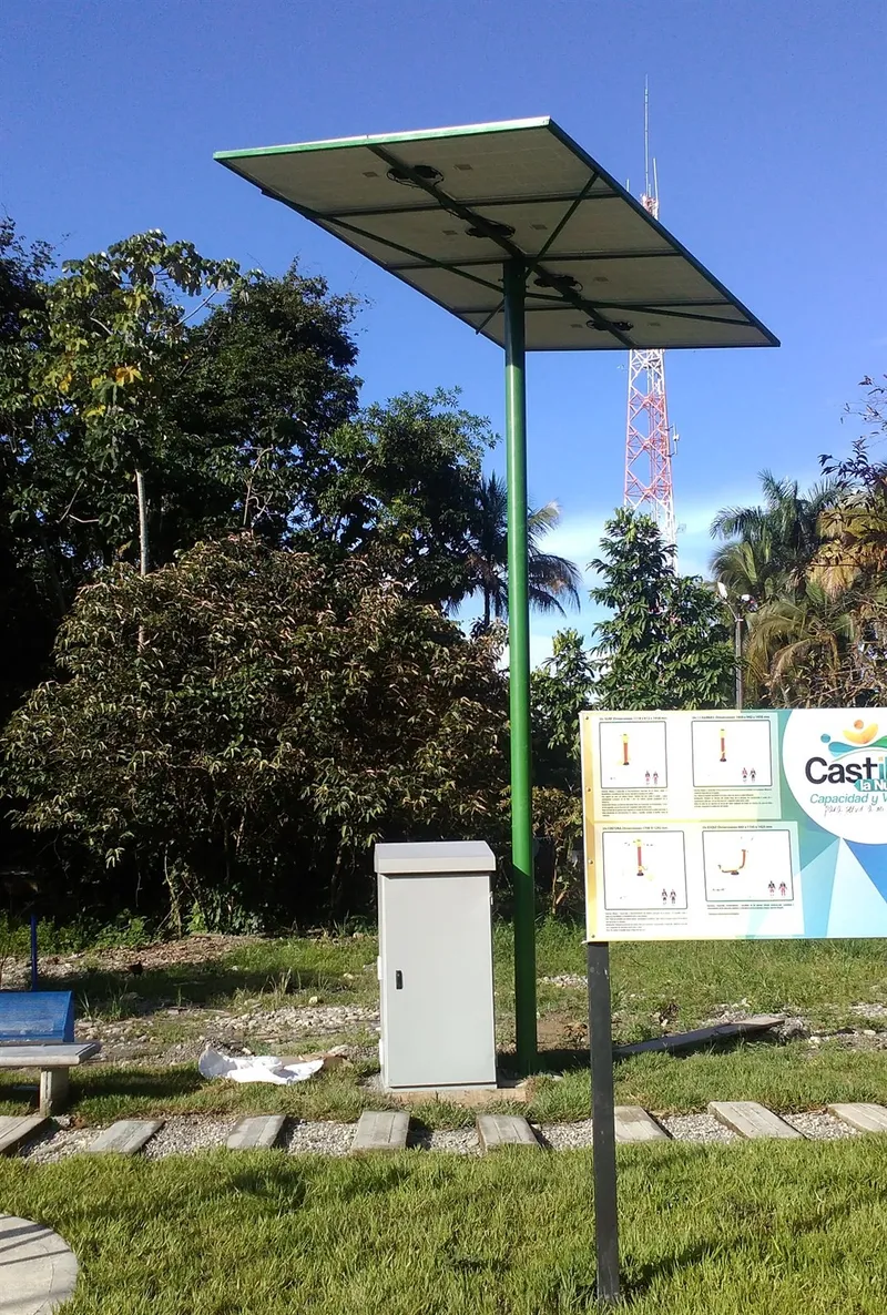 Pérgola solar con el gabinete de control blanco y la valla informativa del municipio de Castilla la Nueva