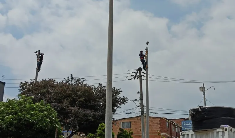 Técnicos de ANGELNET instalando luminarias en altura sobre postes