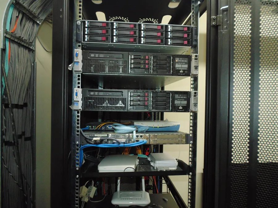 Rack de servidores instalado por ANGELNET, con switches, router y fibra óptica organizados